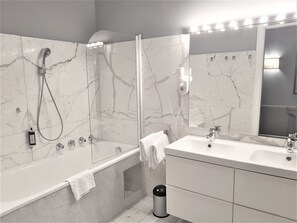A modern bathroom with a glass-enclosed shower, a vanity with a mirror, and a bathtub. - Hotel Kärntnerhof (Vienna)