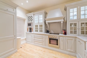 A kitchen with white cabinetry, a built-in oven, and a microwave. - John Lennon Suite - hiphipstay (Dublin)