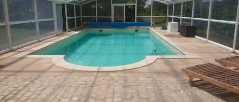 Una piscina cubierta, una piscina al aire libre de temporada, tumbonas