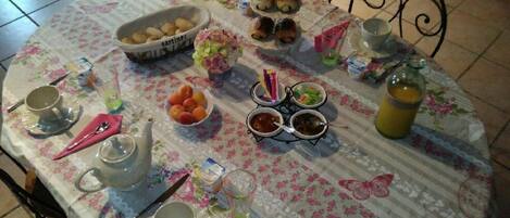 A table set with various food items, drinks, and utensils, suggesting a meal setup.