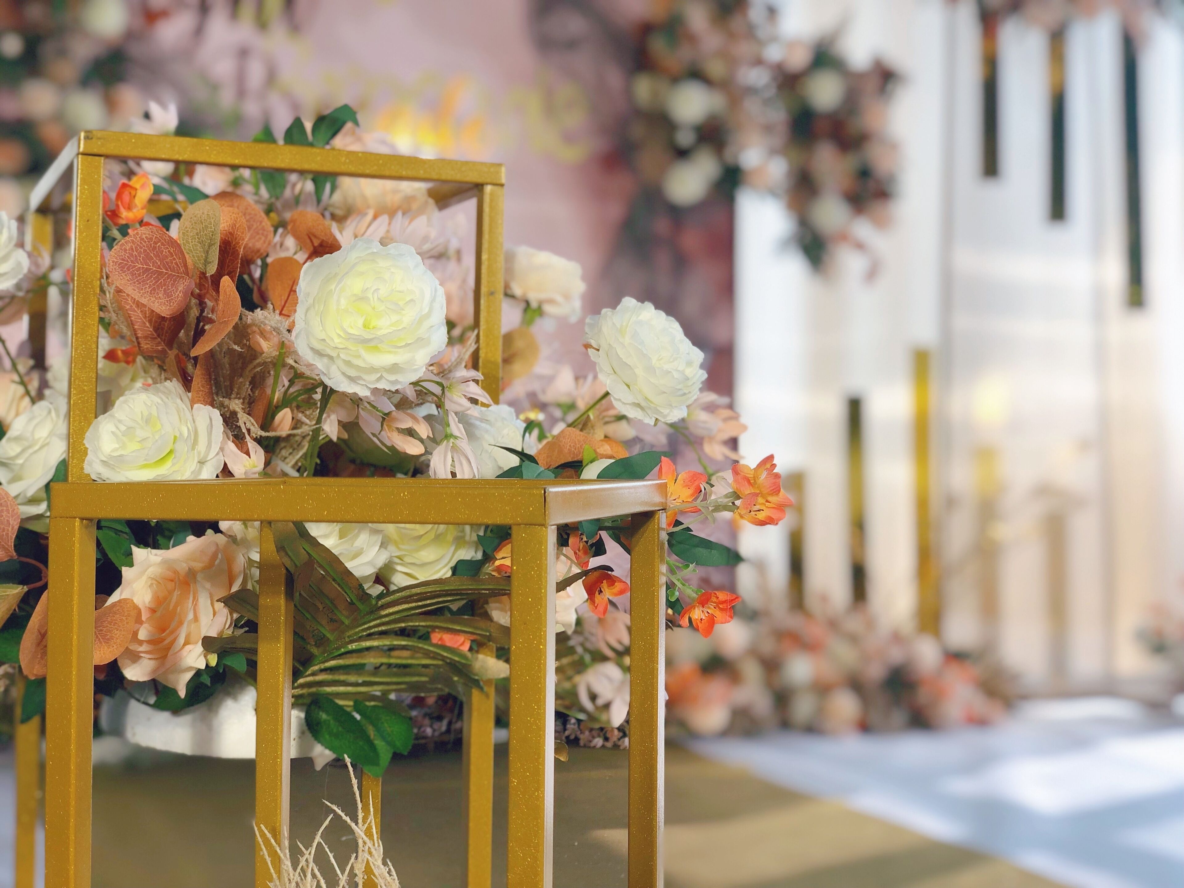 A decorative floral arrangement on a table with a gold frame.