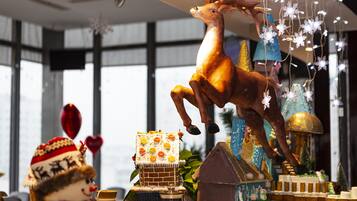 A festive display with a deer, a snowman, and a gingerbread house.