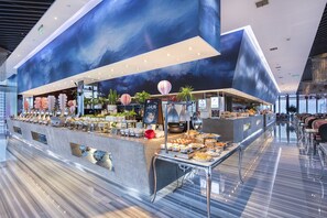 Ein modernes Buffet mit verschiedenen Speisen und einer dekorativen Deckenmalerei.