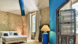 Un dormitorio con cama, lámpara y vistas al exterior.