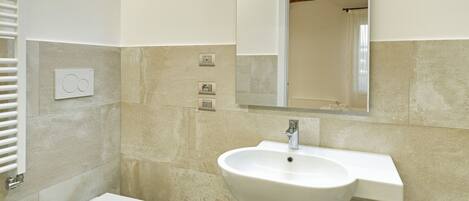 A modern bathroom with a white sink, a toilet, and a bidet.