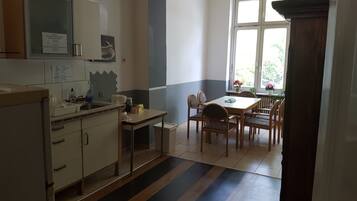 A kitchen with a dining area, a window with a view, and a door leading to another room.