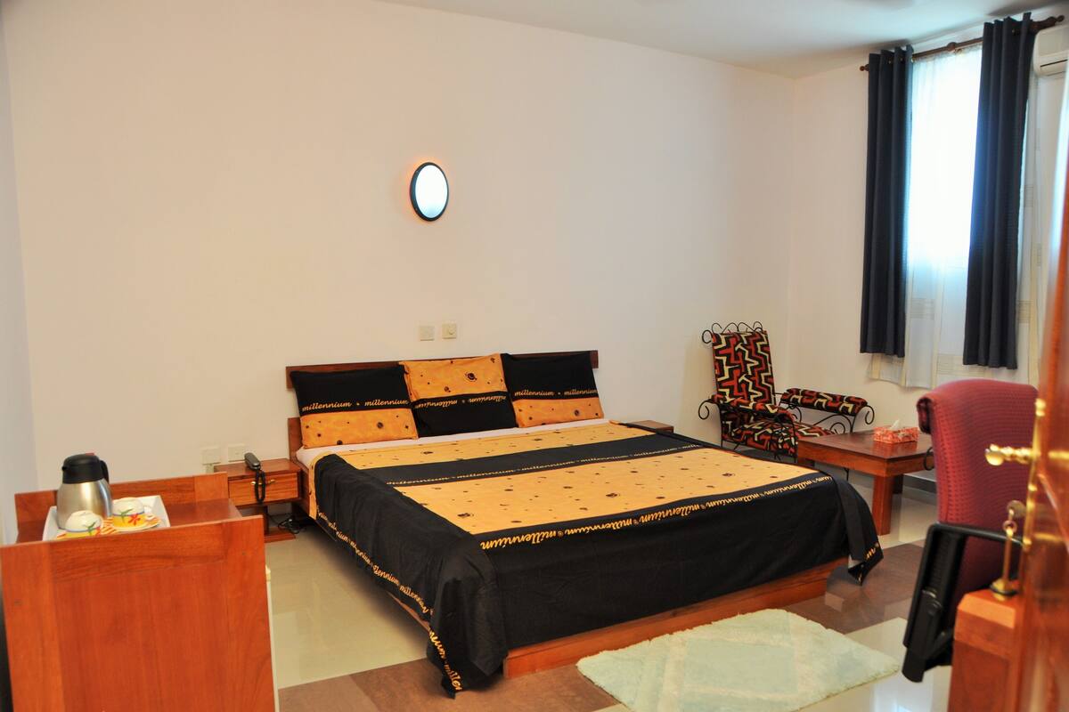 Une chambre à coucher comprenant un lit, une table de chevet, une chaise et un petit bureau avec une chaise.