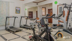 A gym with treadmills, an elliptical, and weight machines. - SwissGha Homes Christian Retreat and Hospitality Center (Tema)