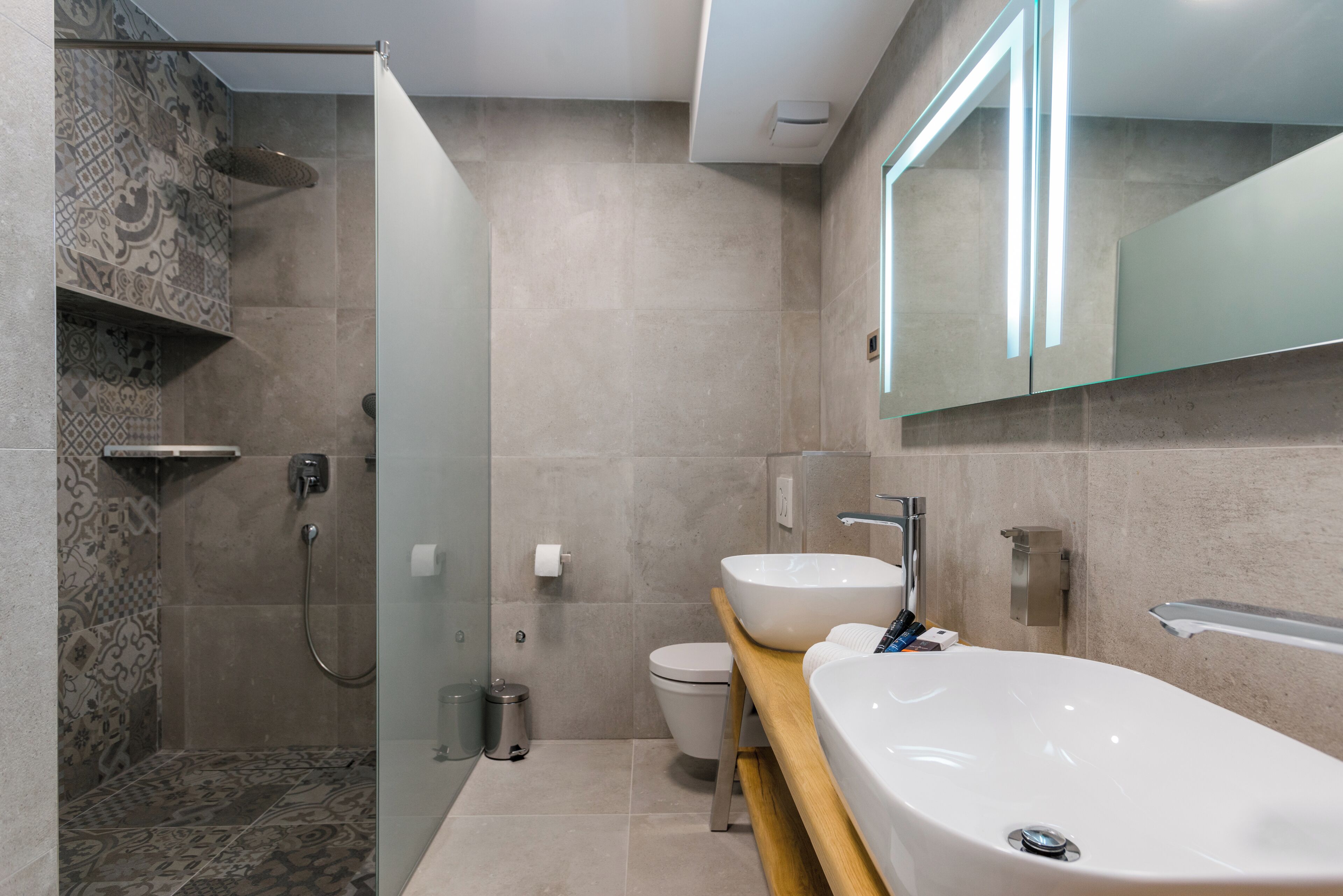 A modern bathroom with a shower, toilet, and a large sink.