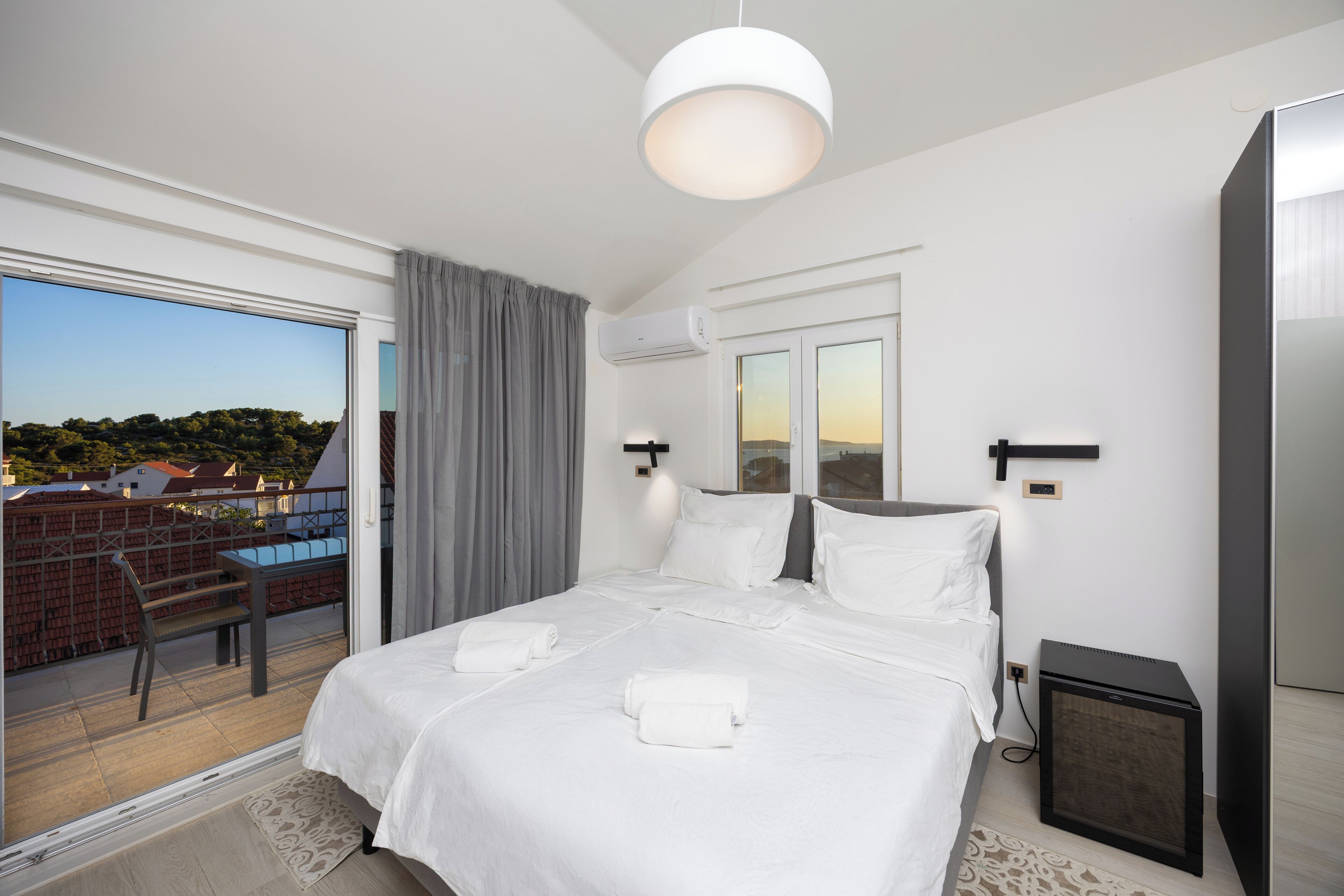 A hotel room with a large bed, a desk, and a view of the city.