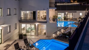 A multi-level residential building with a swimming pool, outdoor seating, and a balcony with a railing. - Hotel Teranea (Hvar)