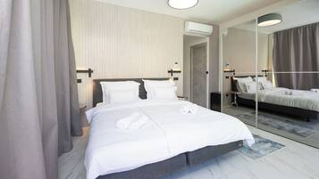 Une chambre d’hôtel moderne avec un grand lit, un miroir et un luminaire au plafond.