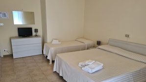 A hotel room with two beds, a TV, a dresser, and a mirror. - Park Hotel (Camaiore)