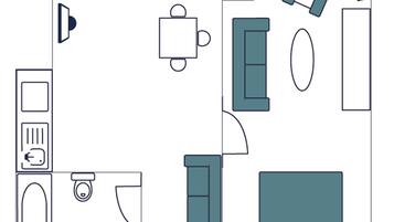 A bedroom with a bed, bedside table, and a window.