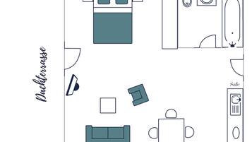 Ein Zimmer mit Bett, Sofa, Couchtisch, Fernseher, Safe und einem Badezimmer inklusive Waschbecken und Toilette.