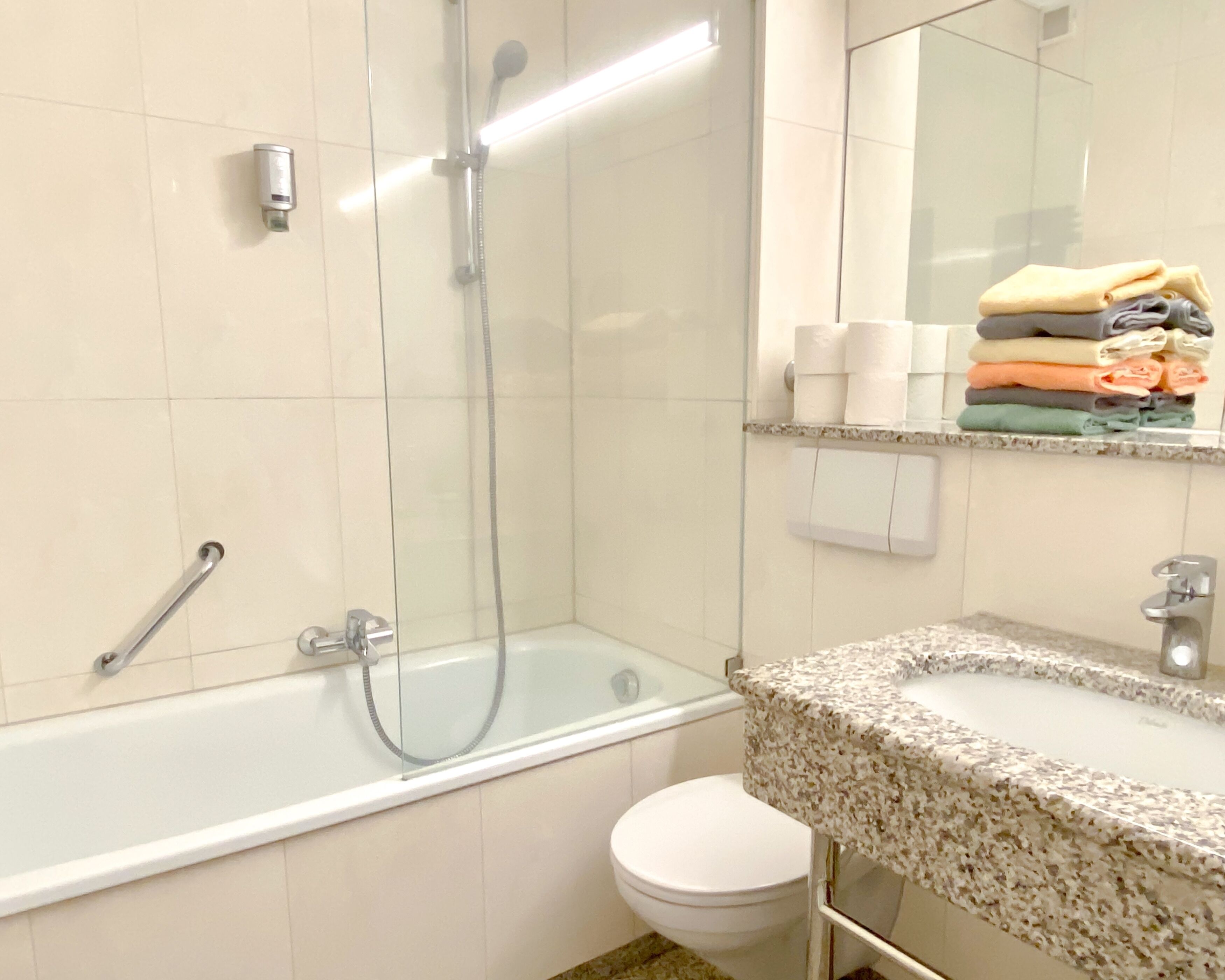 Ein Badezimmer mit einer Badewanne, Toilette und einem Waschbecken mit Spiegel darüber.