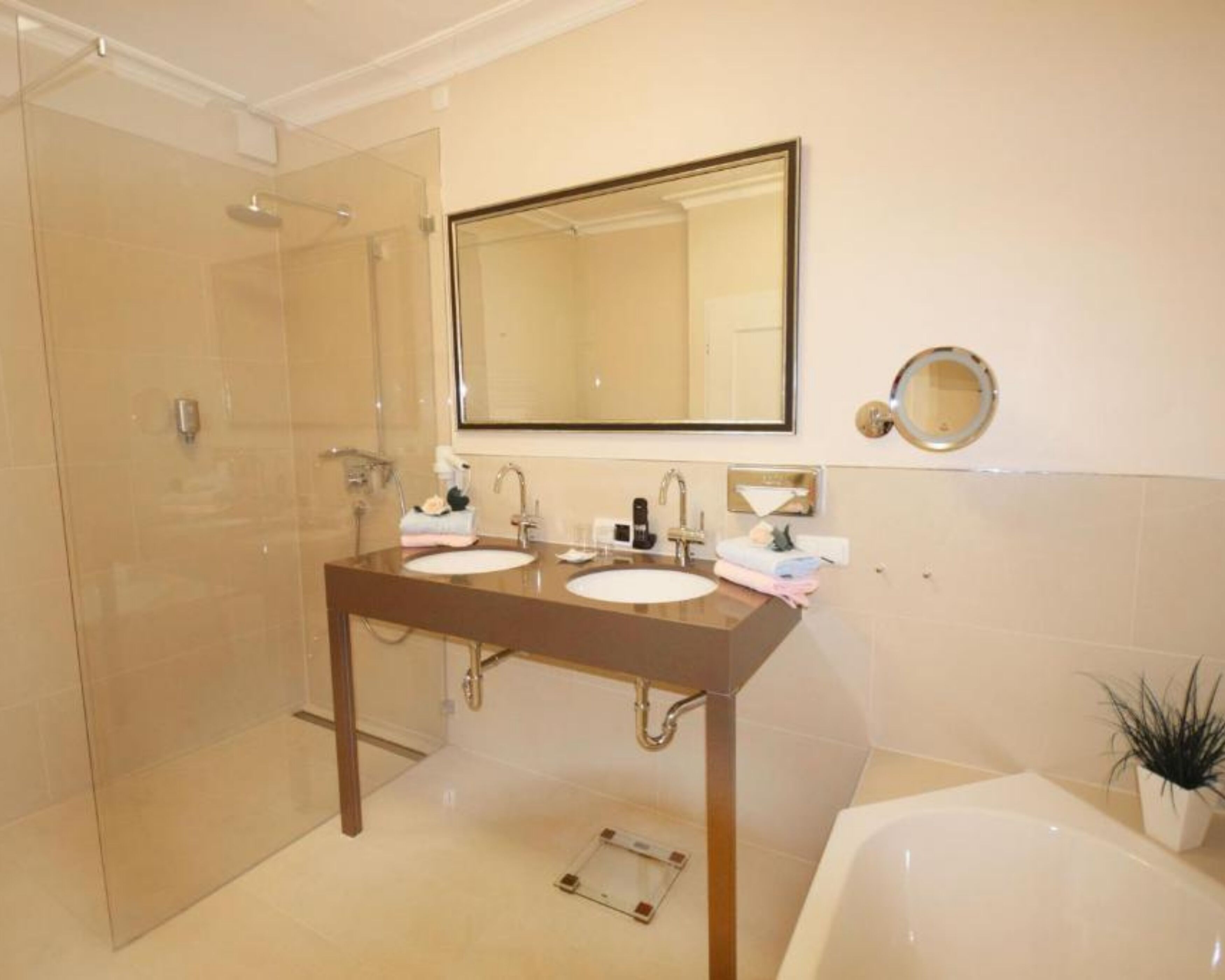 Un baño moderno con dos lavamanos, un espejo grande, ducha y bañera.