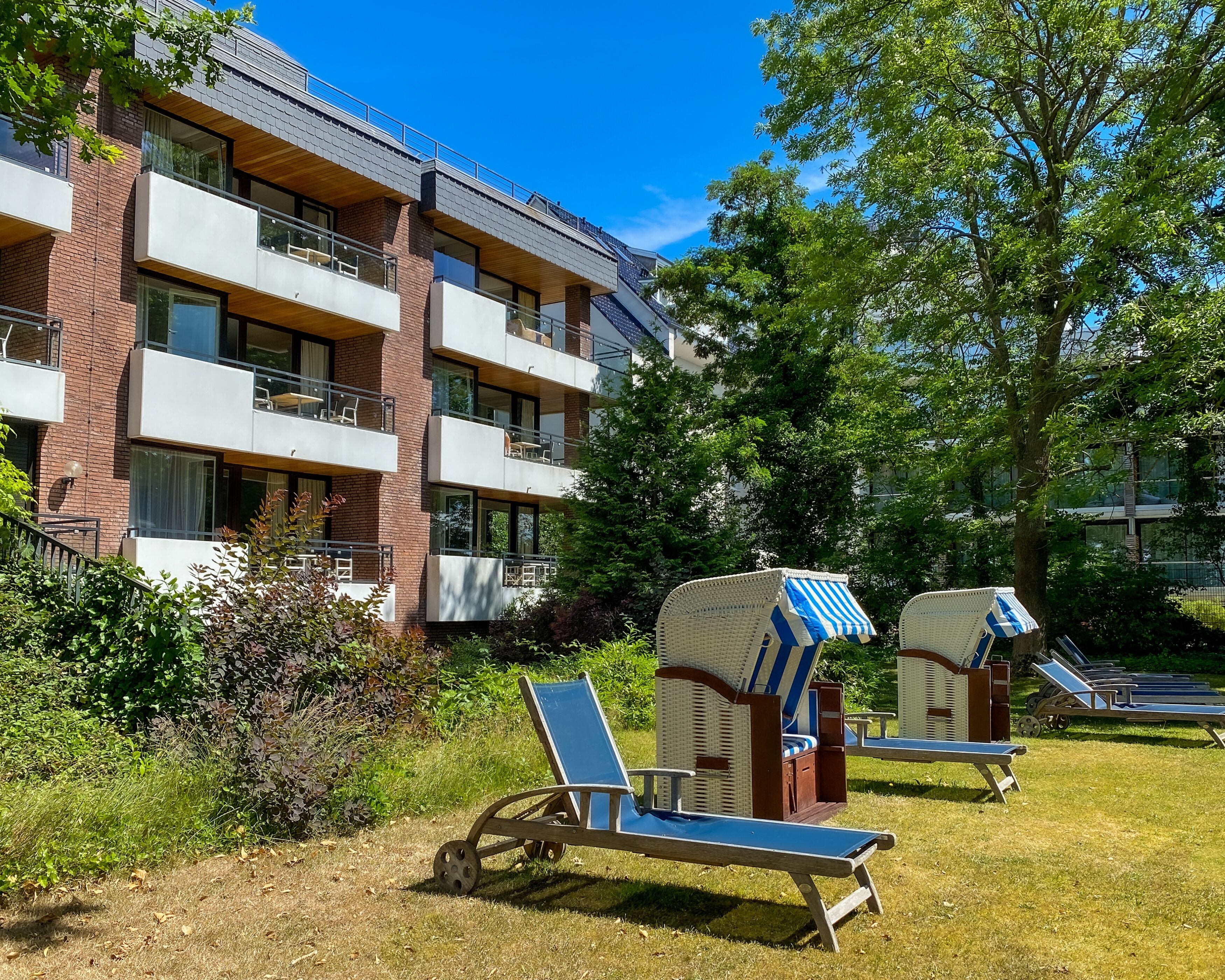 A modern apartment building with multiple balconies and outdoor seating areas.