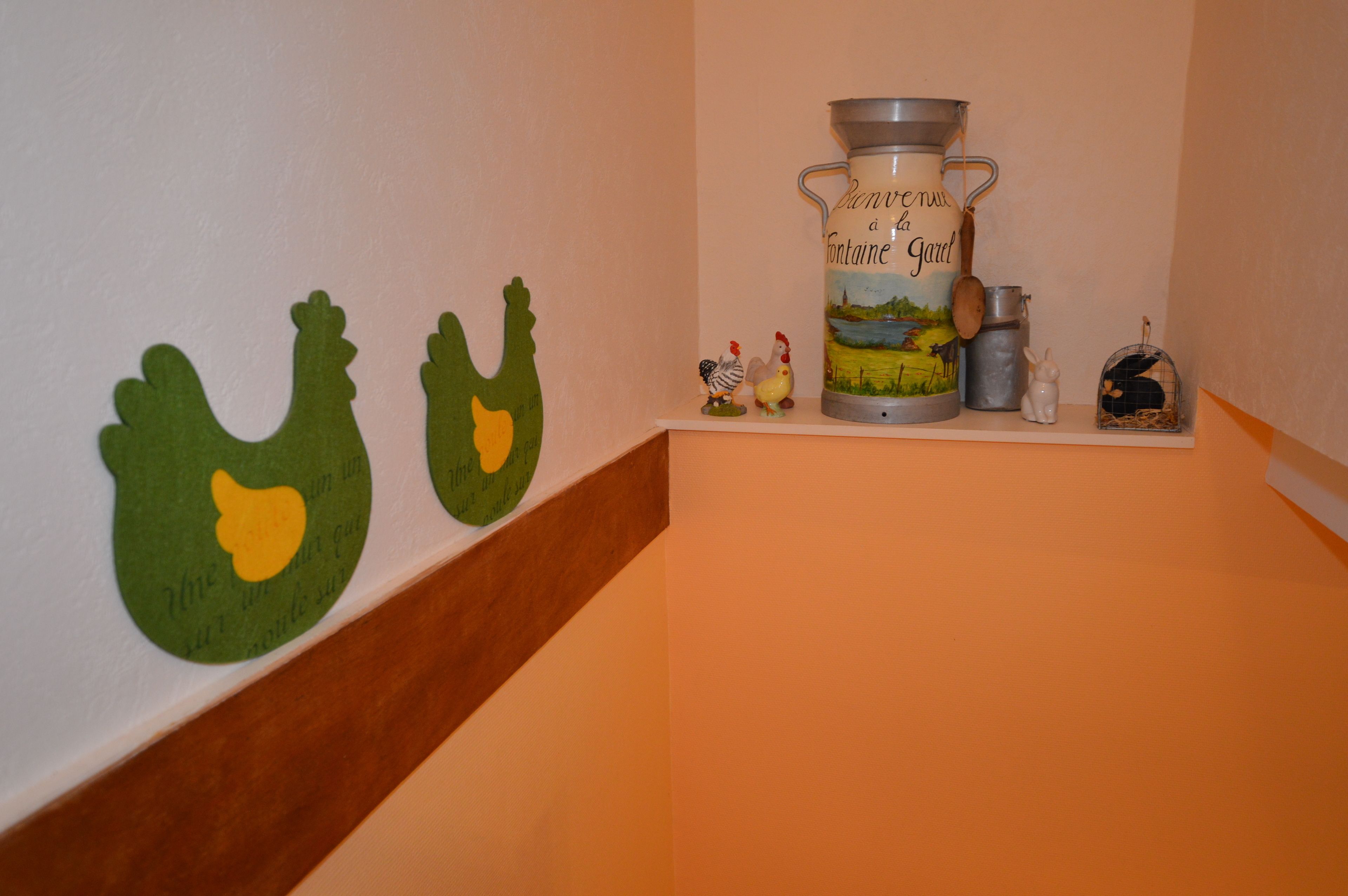 A shelf with a decorative pitcher, a small figurine, and a birdcage.