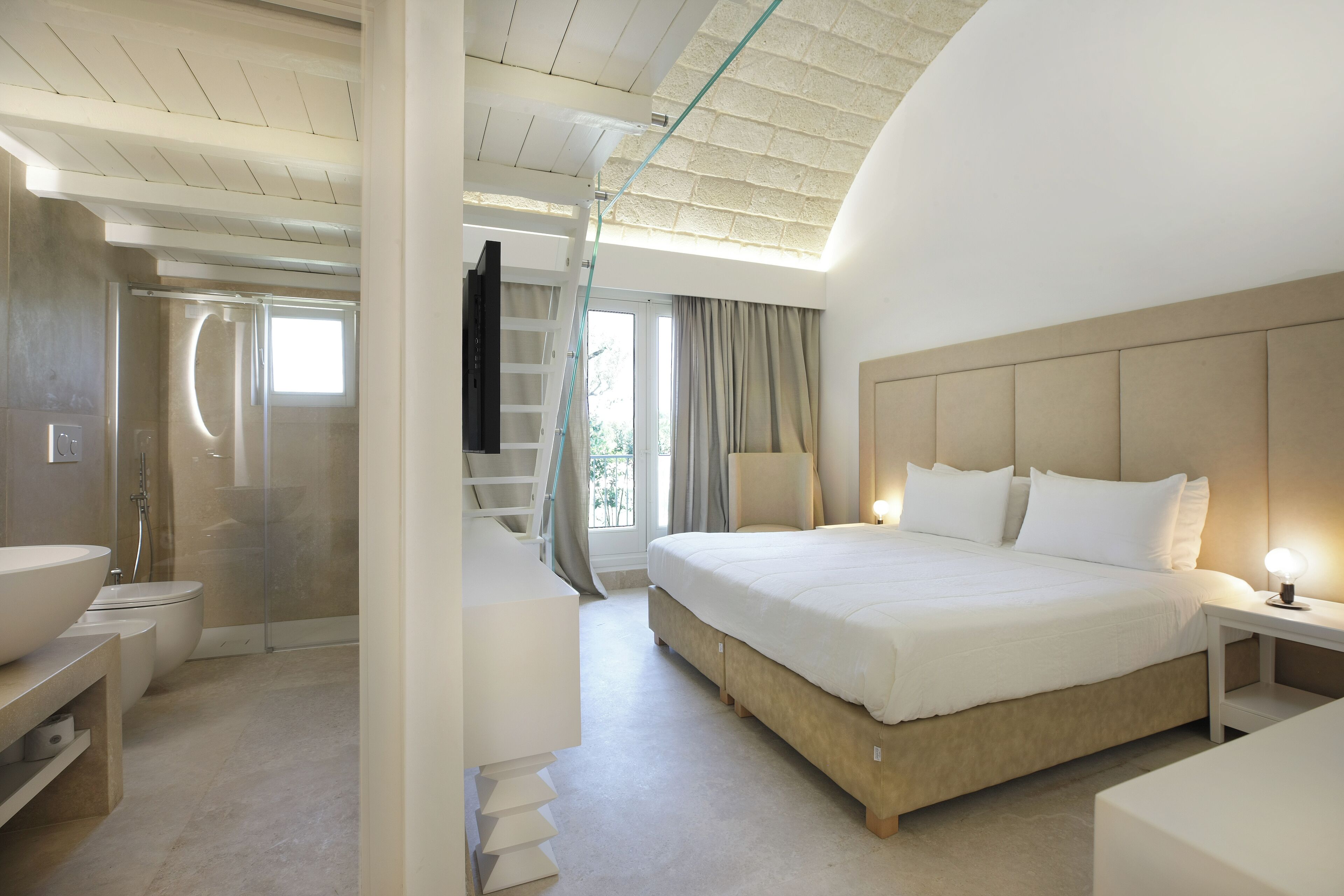 Ein modernes Hotelzimmer mit einem großen Bett, einem Badezimmer mit Dusche und einem Balkon.