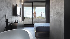 A modern bathroom with a freestanding bathtub, a toilet, and a shower area. - Masseria Antonio Augusto (Leverano)