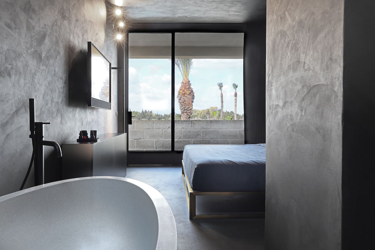 Een moderne badkamer met een vrijstaand bad, een toilet en een douchehoek.