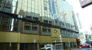 A modern building with a reflective glass facade, a prominent sign for 'Sun Island Plaza', and a parking sign indicating a parking area.