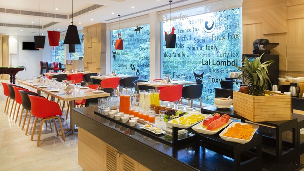 Un buffet de petit-déjeuner proposant une variété d’aliments et une grande fenêtre donnant sur la forêt.