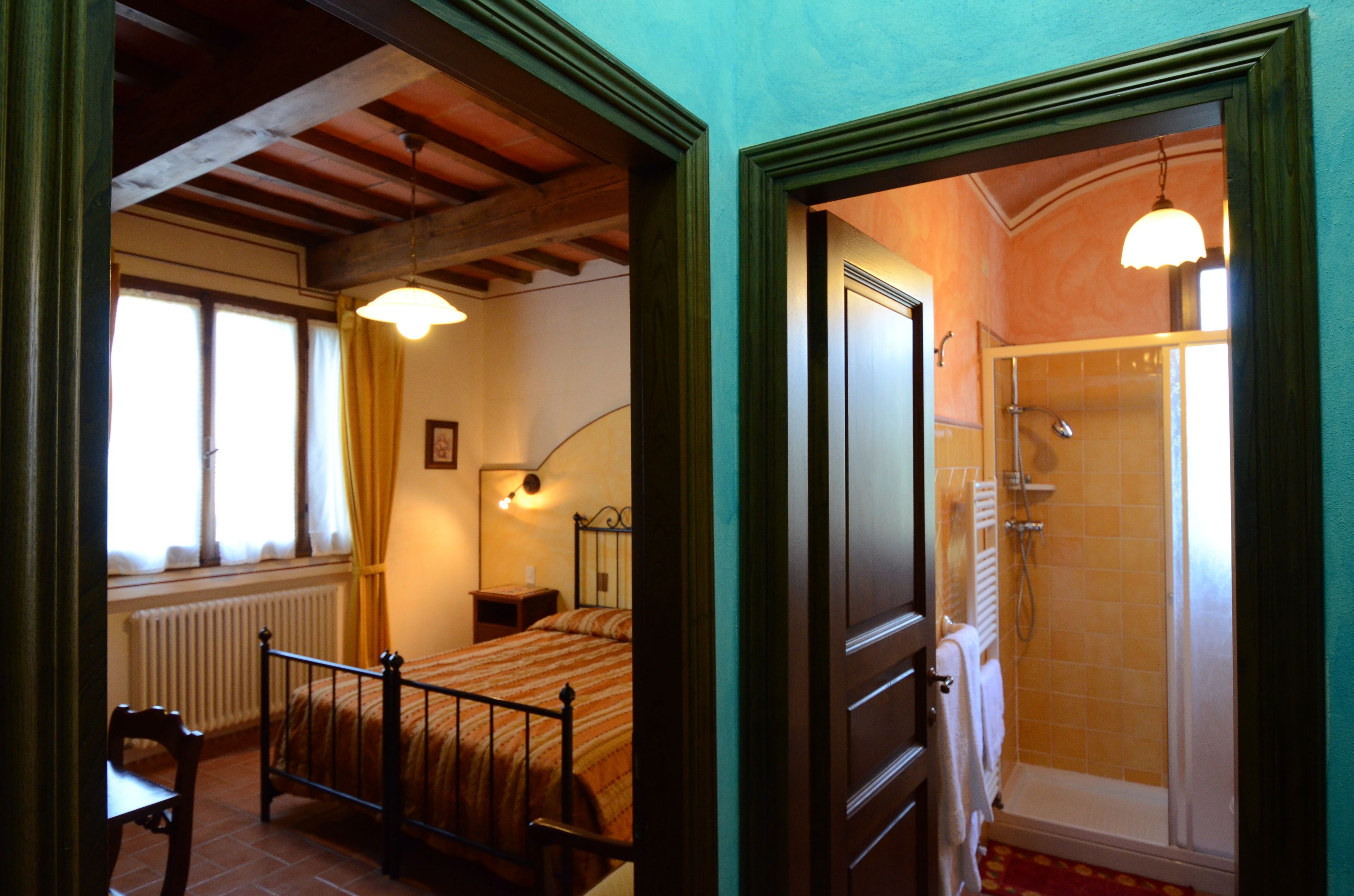 Ein Schlafzimmer mit Bett, Nachttisch und einem Vorhangfenster.