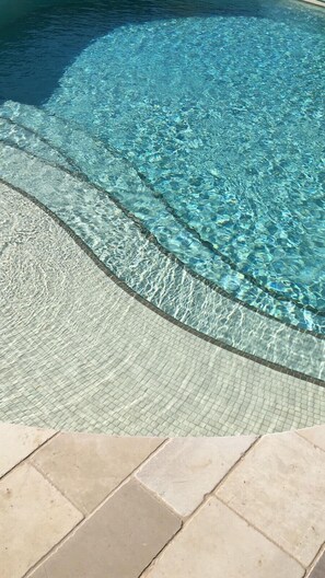 A clear pool with a tiled edge and a tiled walkway leading to it. - Hotel Ristorante Punto Verde (Noci)