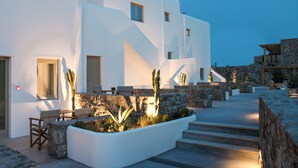 Un edificio moderno blanco con una escalera de piedra que conduce a una terraza plana.