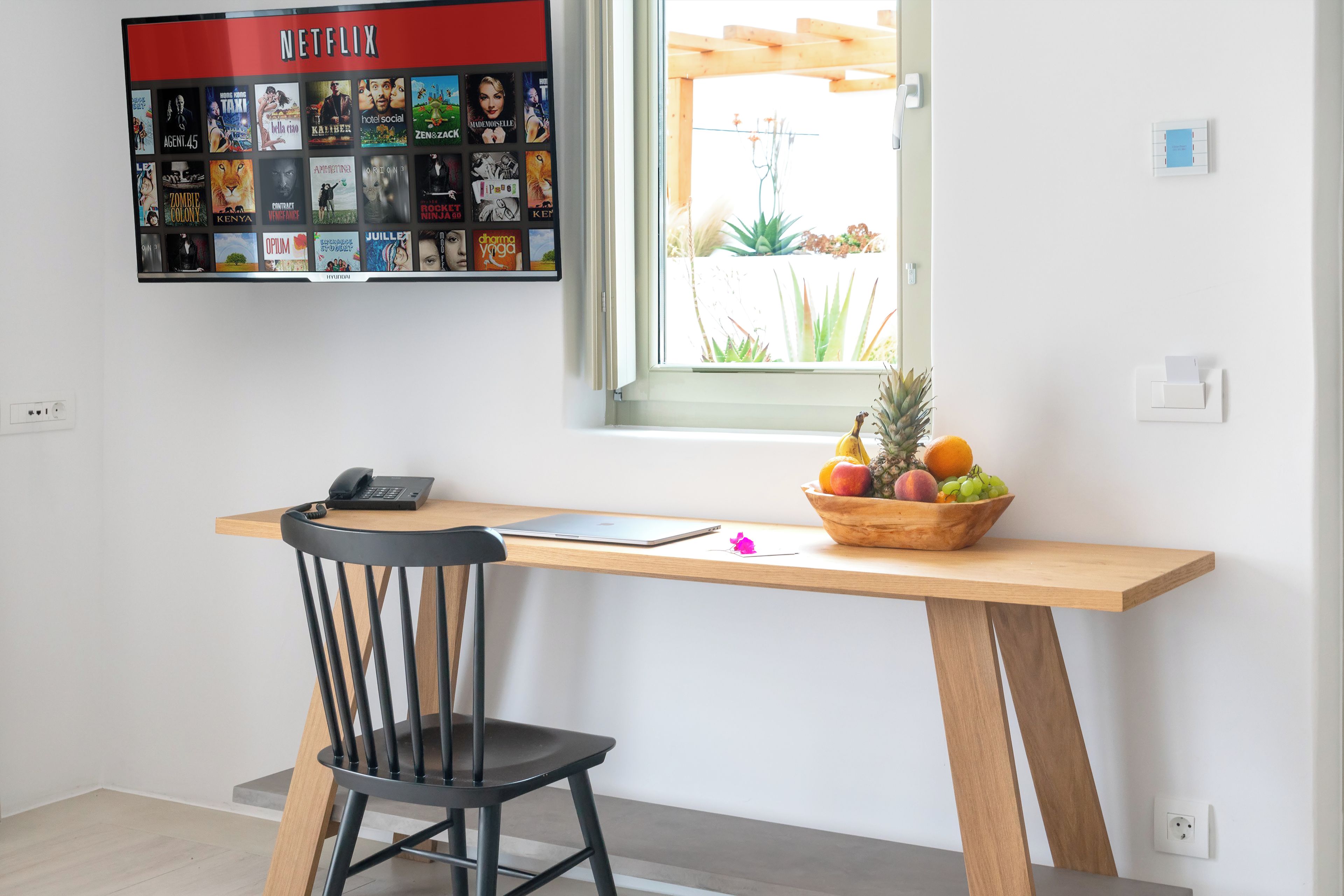 A workspace with a desk, chair, and a wall-mounted display of movie posters.