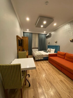 Ein gemütlicher Raum mit einem Bett, einem Esstisch mit Stühlen und einer Couch.