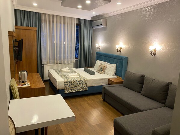 Habitación triple Deluxe | 1 habitación, caja de seguridad en la habitación y insonorización