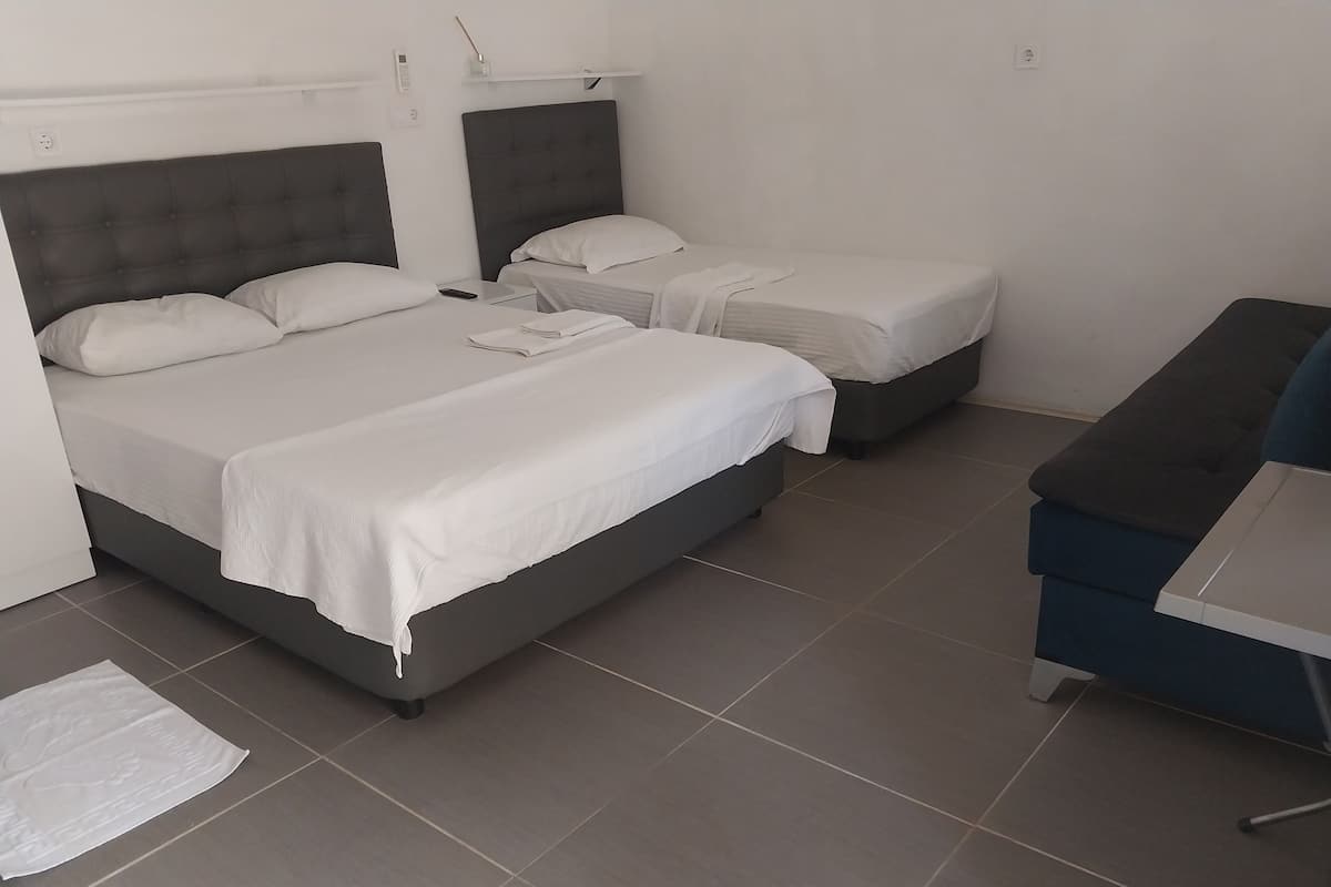 A hotel room with two beds, a desk, and a chair.
