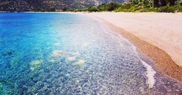 Uma praia com águas azul-claras e uma faixa de areia.