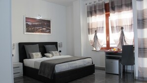 Une chambre à coucher comprenant un lit, des tables de chevet, un bureau et une chaise.