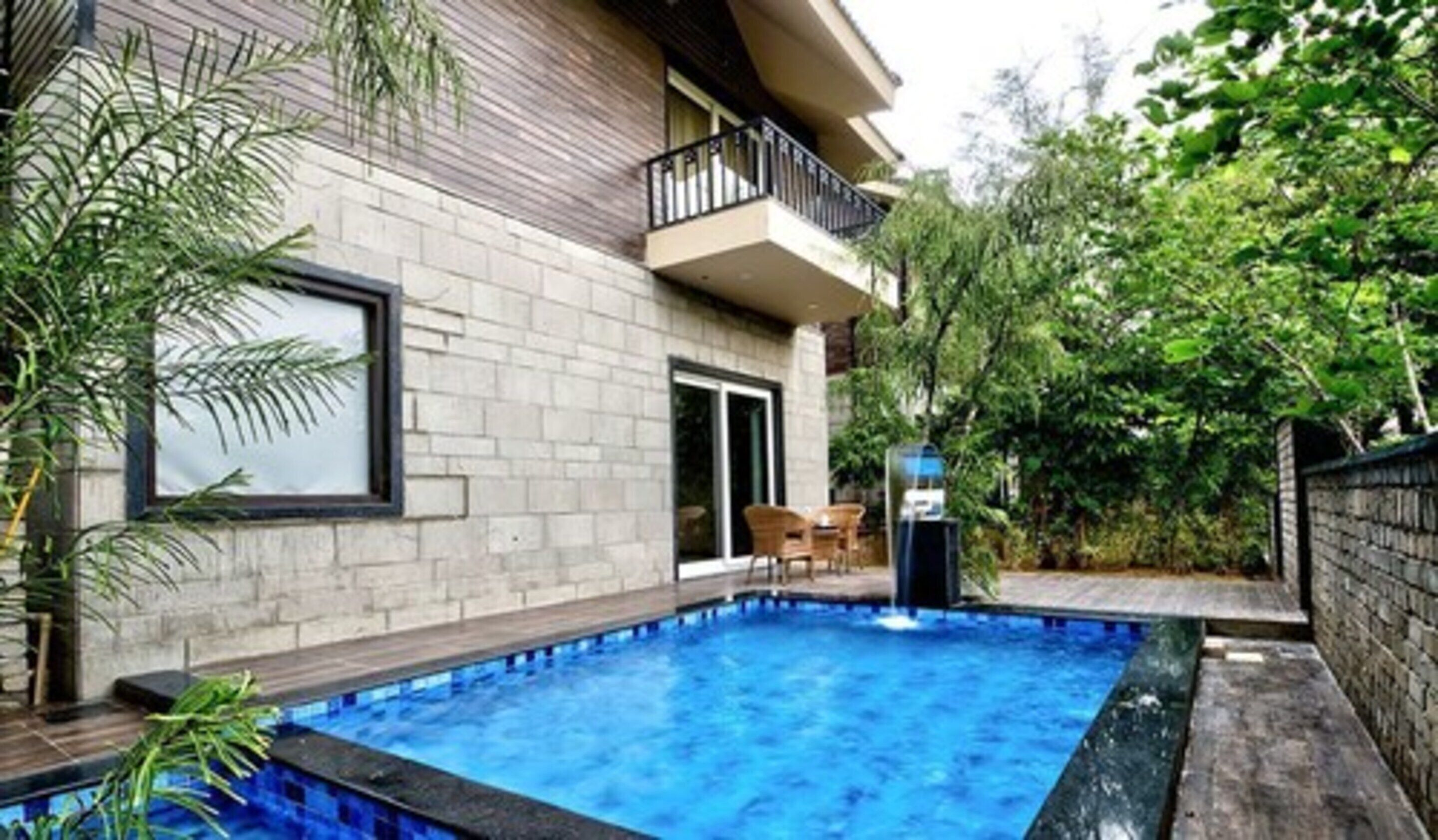 Une maison moderne dotée d’une piscine, d’un balcon et d’un jardin.