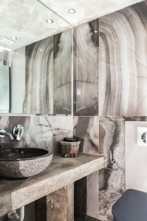 A bathroom with a marble backsplash, a round sink, and a modern design. - Lena Apartments (Thasos)