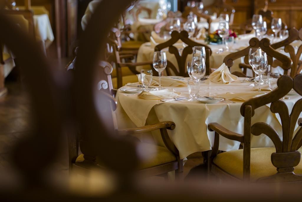 A restaurant with wooden chairs and tables set for dining.