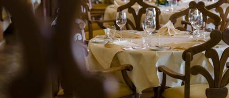 A restaurant with wooden chairs and tables set for dining.