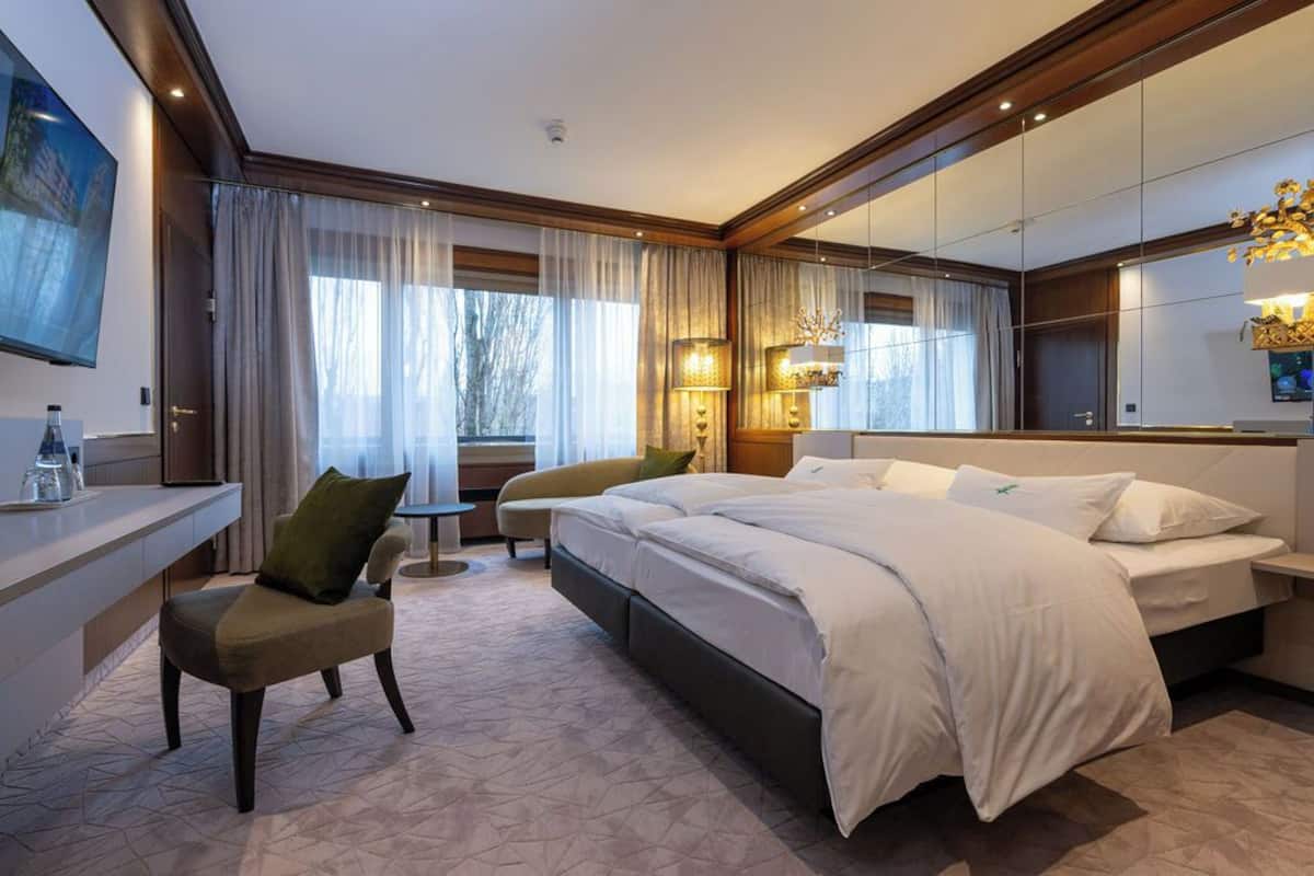 Quarto de hotel moderno com uma cama grande, uma escrivaninha e uma cadeira.