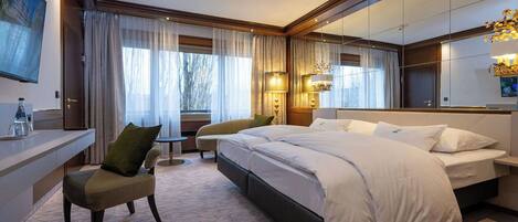 Une chambre d’hôtel moderne, dotée d’un grand lit, d’un bureau et d’une chaise.