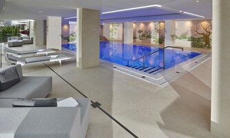 Una piscina techada, sillones reclinables de piscina