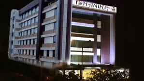 A modern hotel building with a sign that reads "SHANKIR". - Ishanika Hotel (Lucknow)