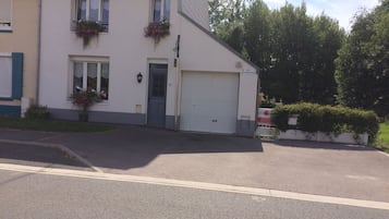 A two-story house with a garage, a front door, and flower boxes on the windows.