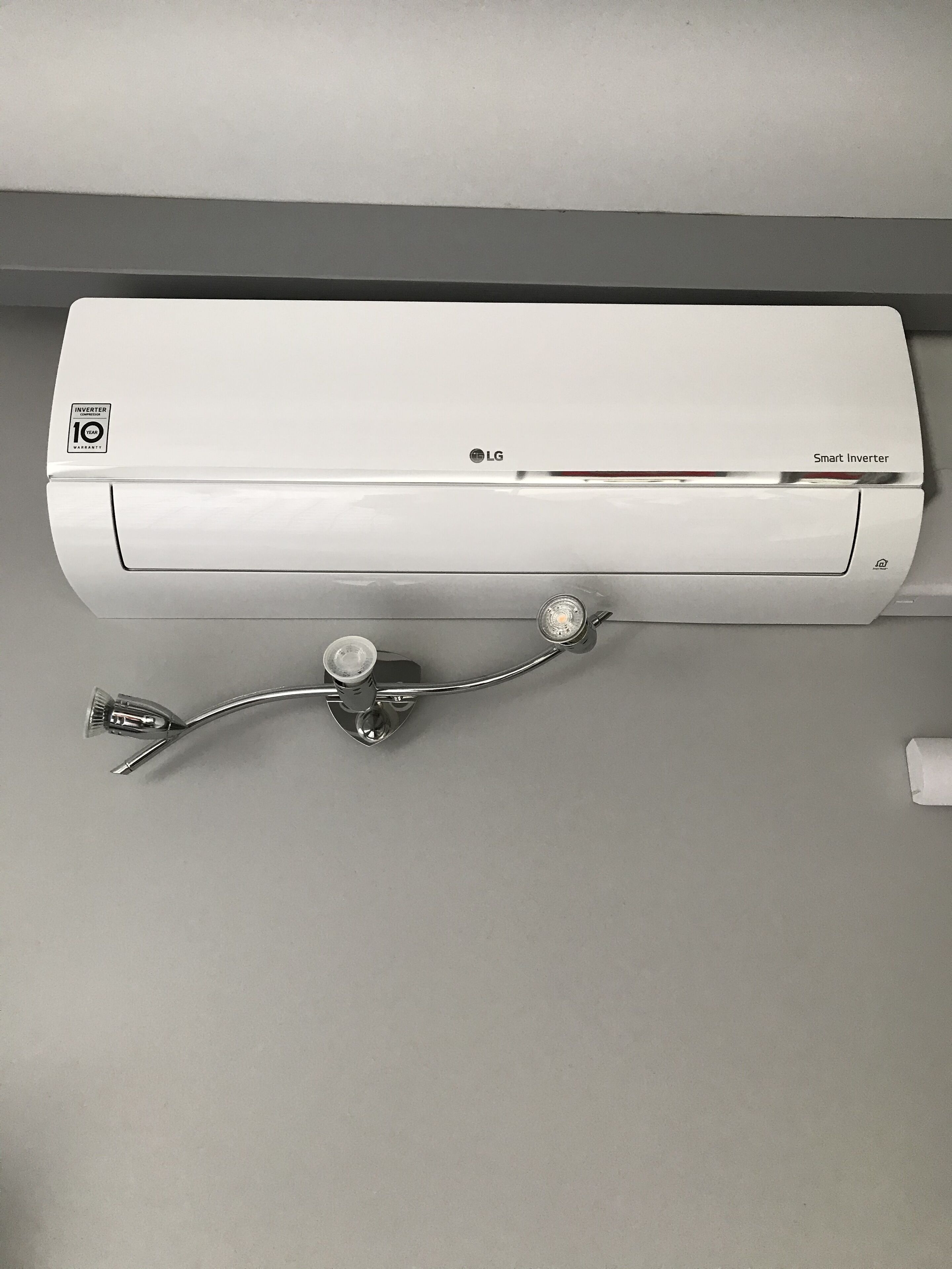 A white LG smart inverter mounted on a wall.
