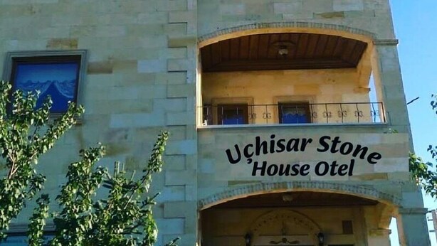 Rakennuksessa on suuri kupoli, ja sen julkisivussa lukee teksti: ”Uchisar Stone House Hotel”.