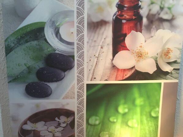 Uma colagem com quatro cenas distintas: uma mesa iluminada por velas com um copo de água e uma flor, uma garrafa de líquido vermelho ao lado de flores brancas, uma tigela com flores brancas e um close-up de folhas verdes com gotas de água.