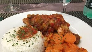 Un plato con arroz blanco, un guiso de carne y zanahorias en rodajas.